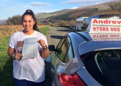 Michaela posing by Marcus's driving school car