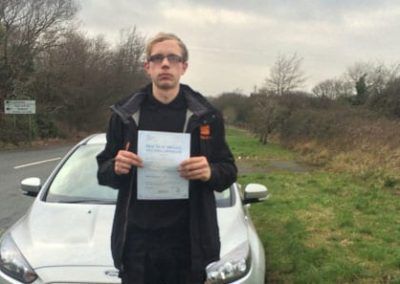 Joe standing by driving school car in Colwyn Bay